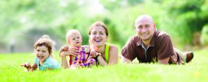 Happy family of four enjoying time at grass