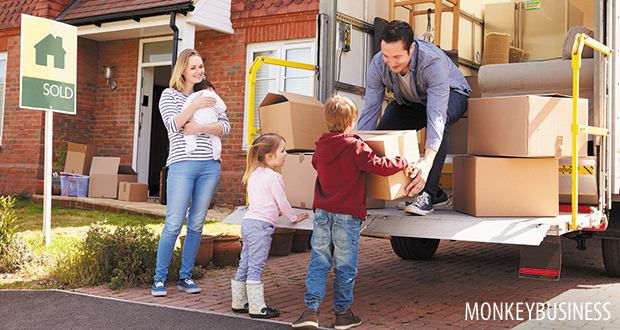 Family Unpacking Moving In Boxes From Removal Truck